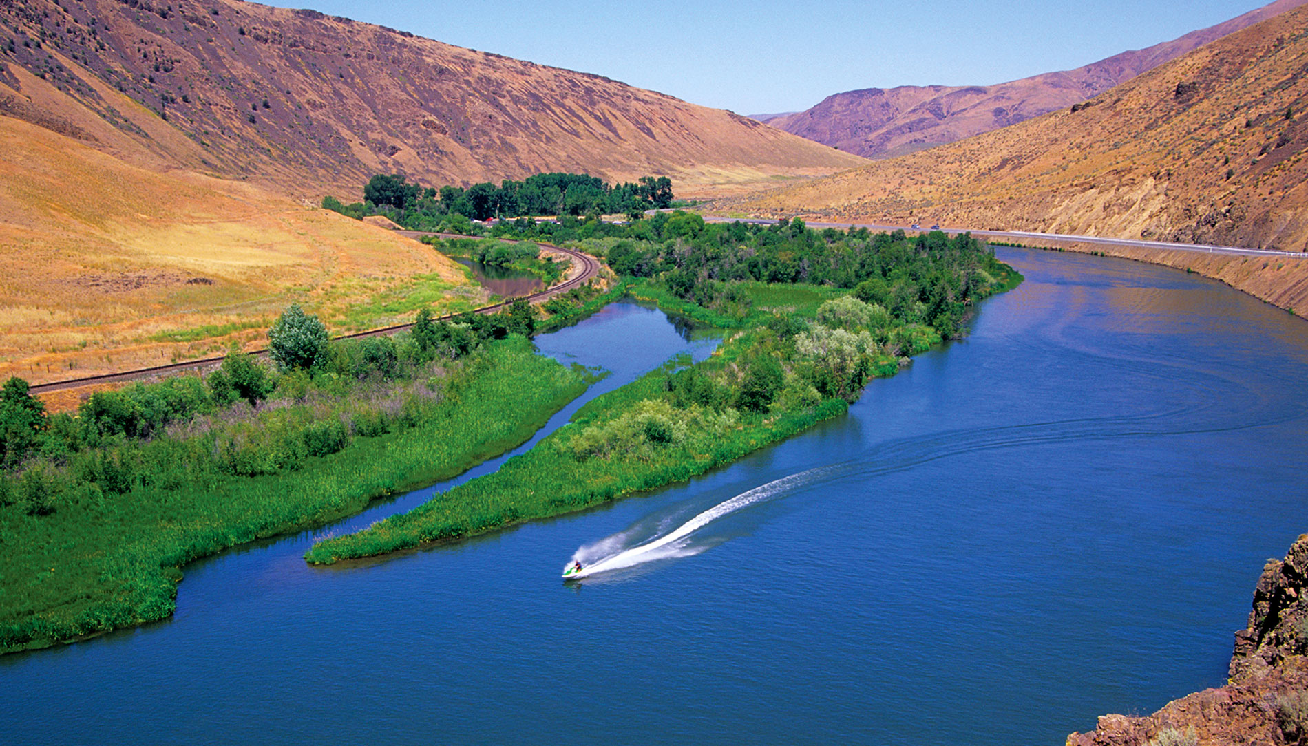 A Jet Ski cruises the blue waters of the Yakima River Canyon between Roza Recreation Site and Roza Dam.