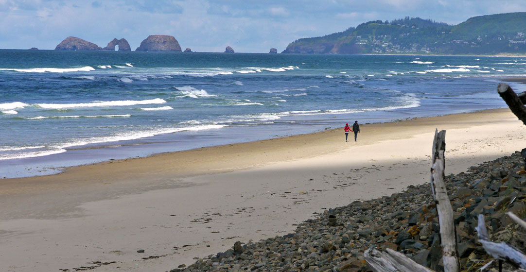 A couple on a romantic getaway walk along the beach at Cape Lookout State Park