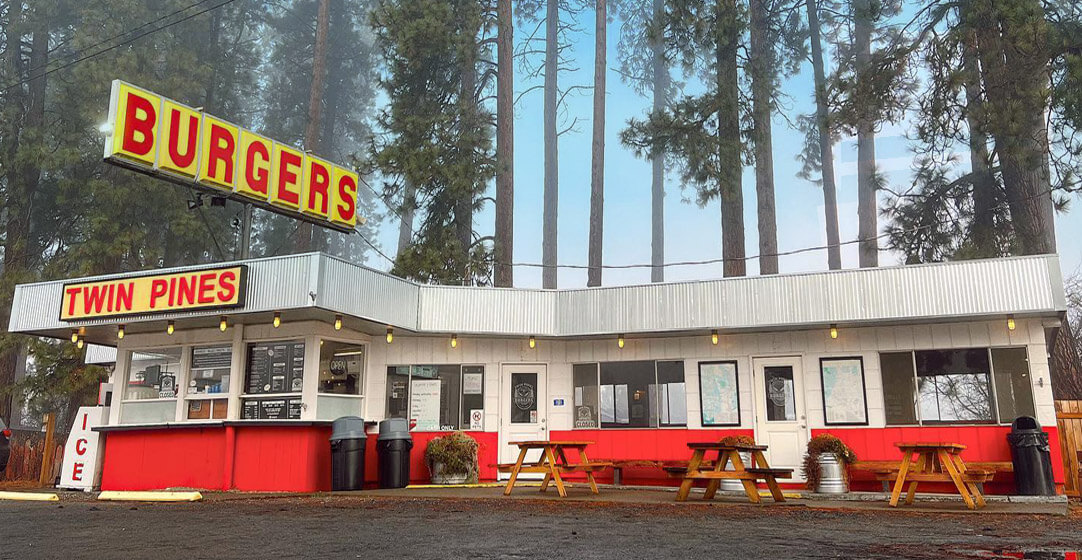 Classic burger joint, white flat-roofed building with sign spelling out Burgers in red letters