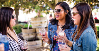 Three women wearing sunglasses sipping wine in the Yakima Valley