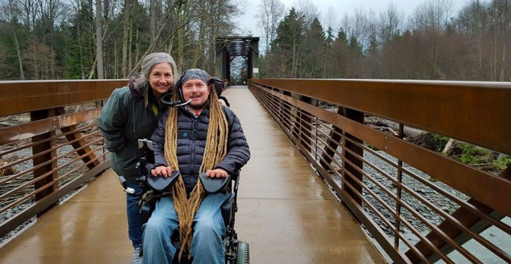 Two people on a wood trail on the Olympic Discovery Trail. Explore great Washington hikes with accessible features for people with limited mobility