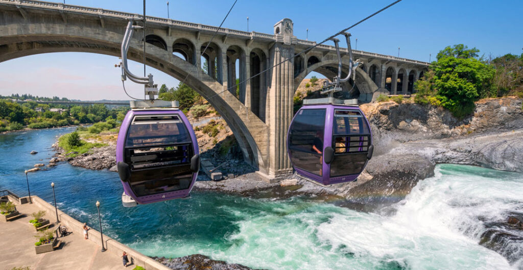 Two gondolas fly over the Spokane River