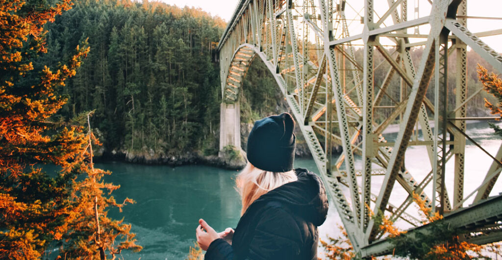 Woman at the bottom of Deception Pass Bridge, the gateway to Whidbey Island