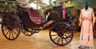 A 1800s era carriage and Victorian period pink dress