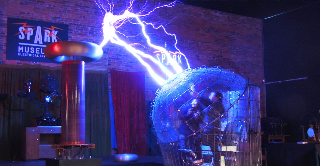 Lighting flies off a 9-foot tall Tesla Coil and strikes a cage at the Spark museum in Bellingham.