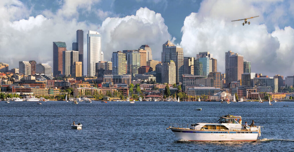 A picture of the Seattle Skyline from Lake Union in Washington states with boats passing by to demonstrate the importance of boat insurance