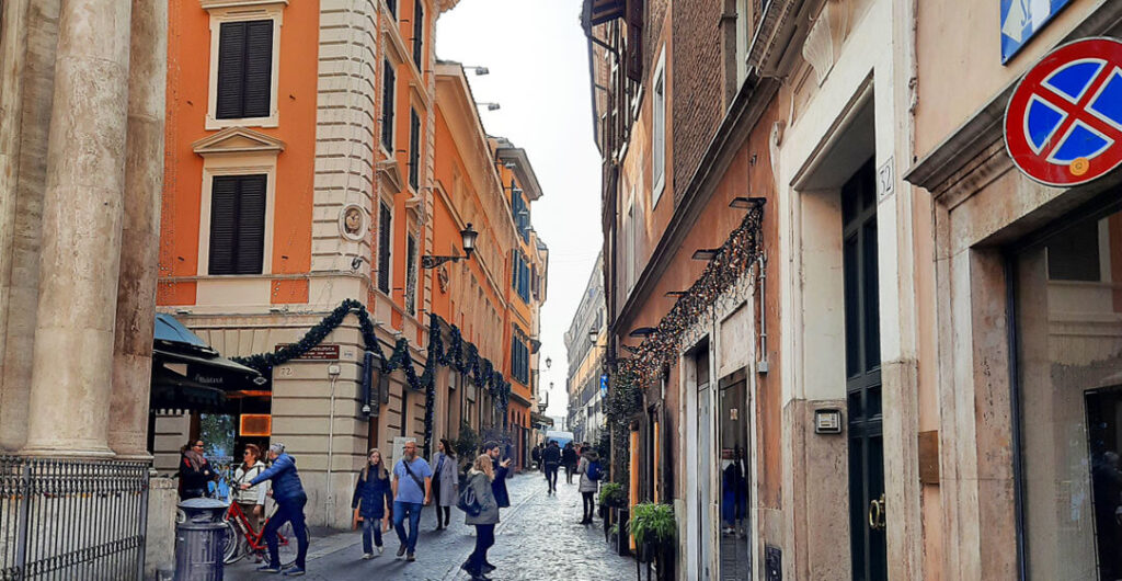 People walk within one of Rome's narrow cobblestone streets. The weather in Rome in the off-season,  especially February, was great for walking in a city that can get oppressively hot during the peak tourism season.