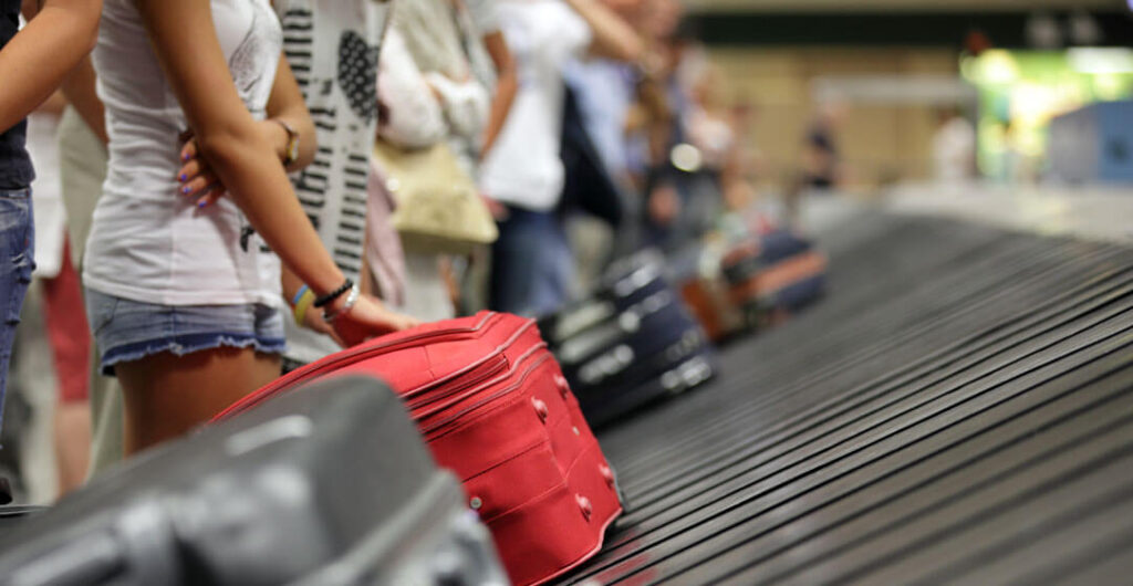 Baggage on an airport carousel to illustrate travel insurance. Travel insurance will usually reimburse you for lost and stolen baggage up to a certain limit.