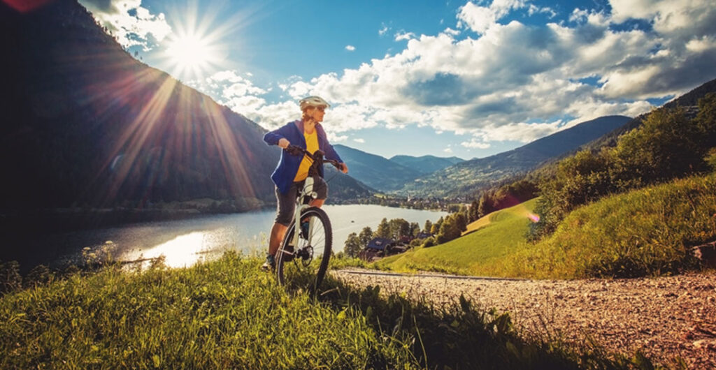 A woman rides an e-bike in the mountains to illustrate e-bike popularity, 