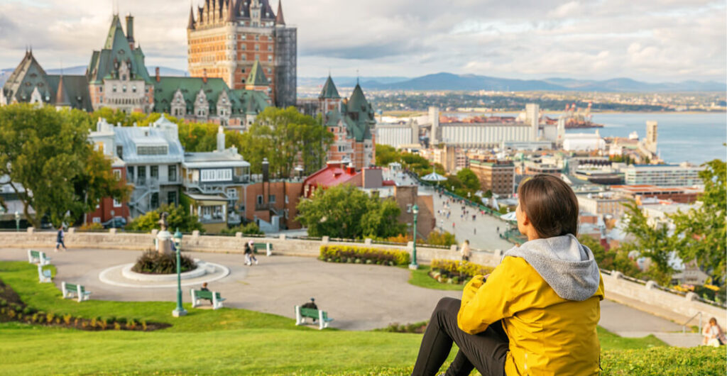 A woman enjoys a view of the Chateau Frontenac Castle and the St. Lawrence River in Quebec City