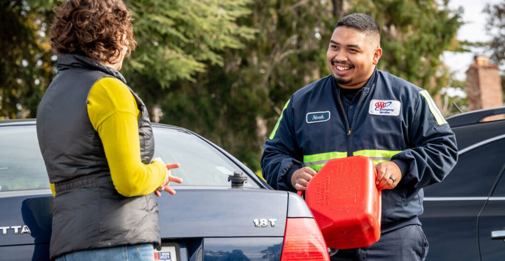 A AAA service provider delivers fuel to a woman stranded on the road, to illustrate one of the perks of a AAA Washington membership.