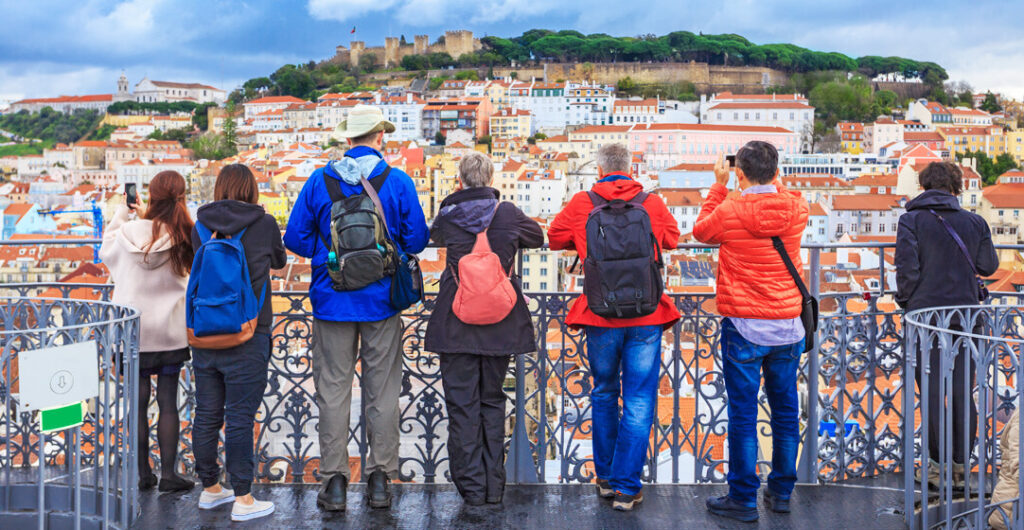 Tourists taking photos in Lisbon. With a little preparation, you can avoid many common travel illnesses. 