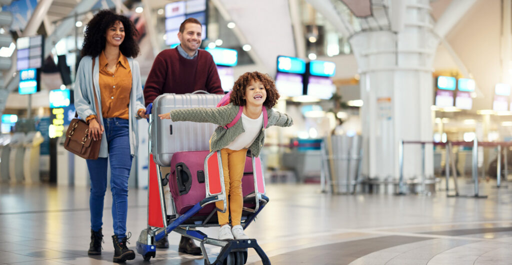 Pictured here, a family prepares for a long flight in an airport. In this blog post, we'll look at common travel illnesses that may occur because of the location or climate during your journey and what you can do to stay healthy.