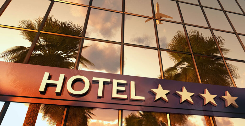 Hotel and hotel sign with plane flying in distance