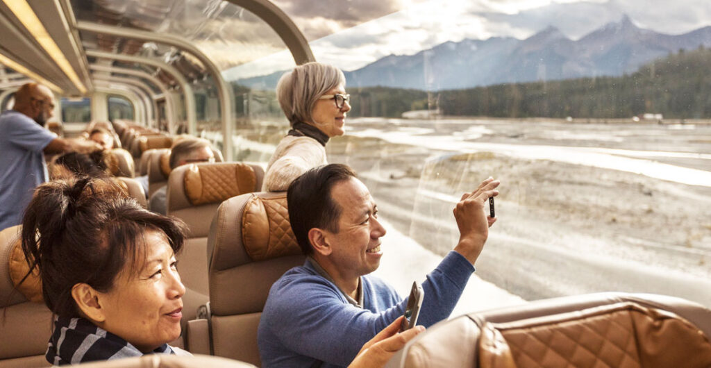 A couple takes pictures of the river onboard the first class domed car on the Rocky Mountaineer train during a trip through western Canada.