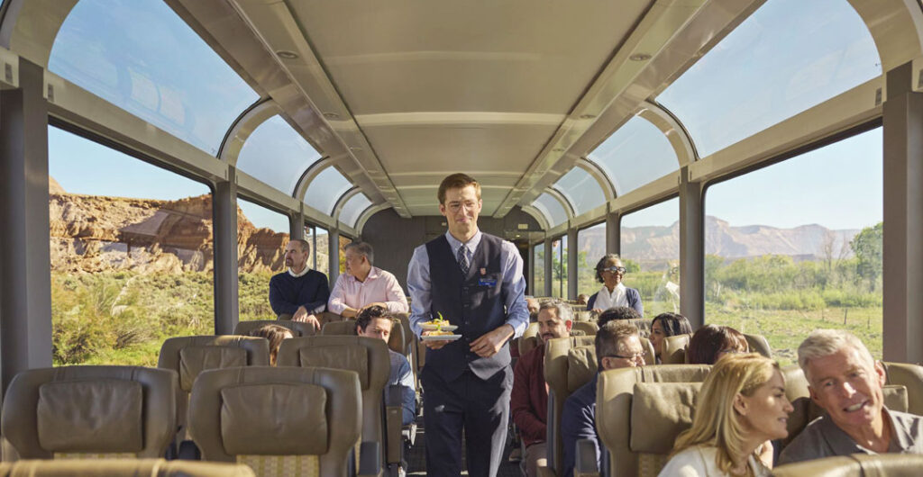 A server on the Rocky Mountaineer brings food out to guests seated in the second class SilverLeaf car. 