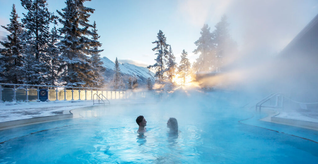 Two people enjoy a warm dip in a hot springs at Banff 